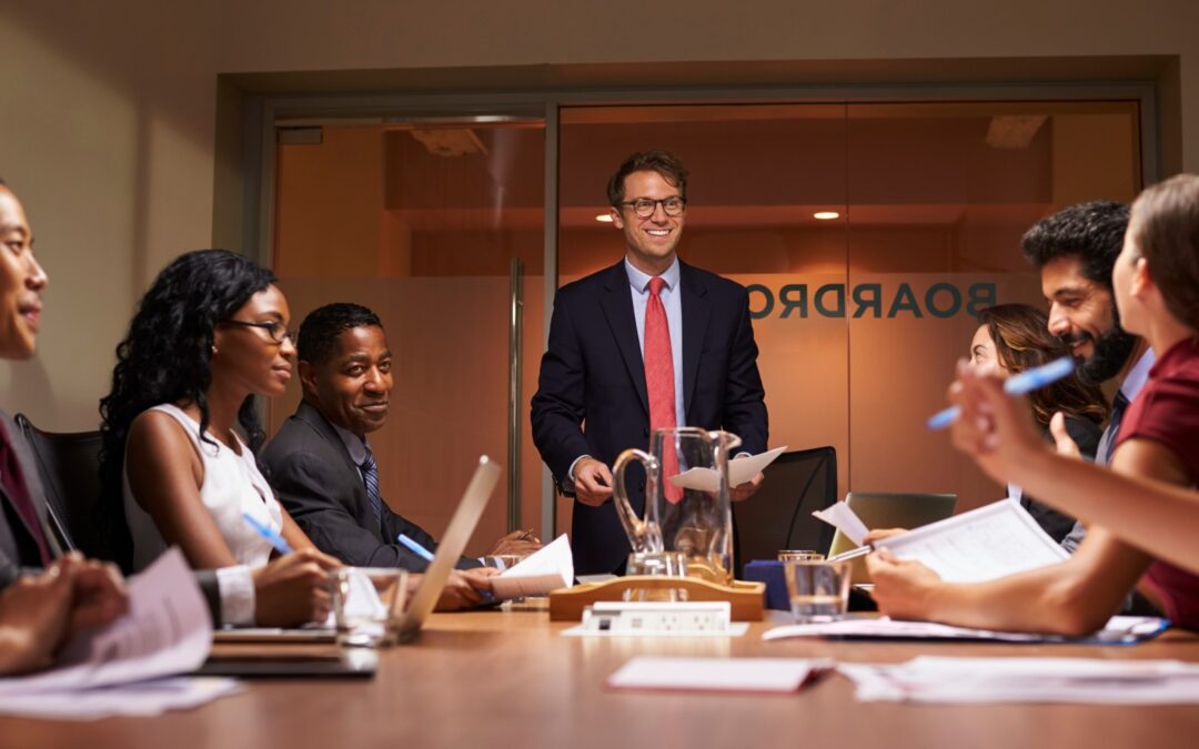 smiling-businessman-addressing-team-at-meeting-lo-2026-03-10-03-17-54-utc-1-1